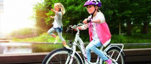 Mädchen mit Fahrradhelm fährt auf einem Kinderfahrrad
