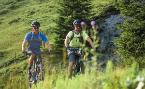Zwei Radfahrer fahren auf Mountainbikes durch die hügelige Landschaft